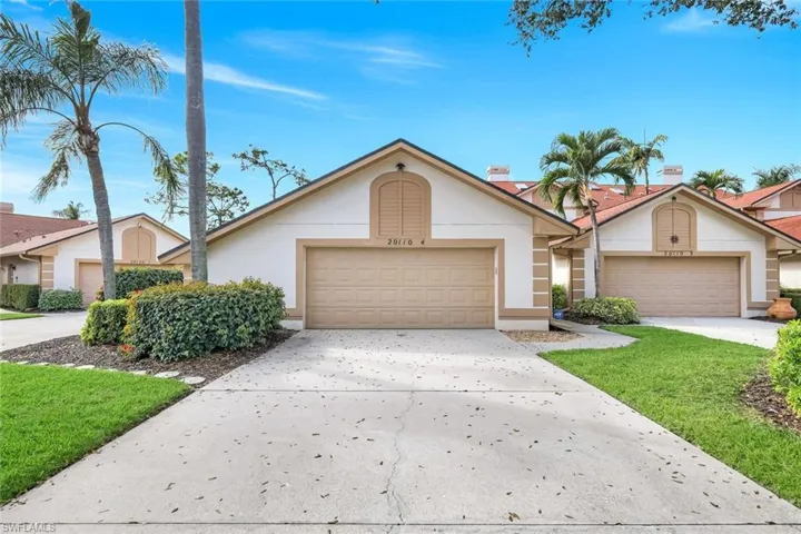 View of front of home featuring stucco siding, driveway, and a garage
