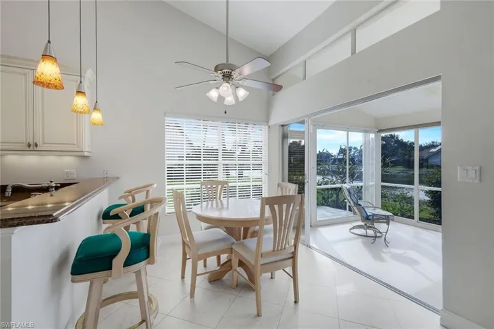 Dining area featuring lofted ceiling, ceiling fan, and light tile patterned floors