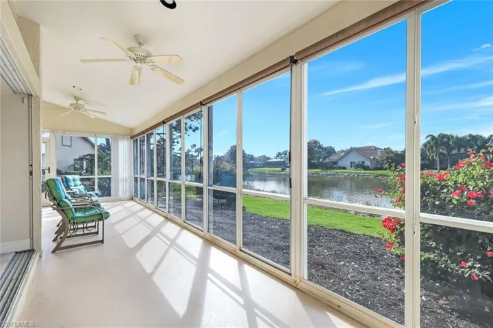 Unfurnished sunroom with a ceiling fan, lofted ceiling, and a water view