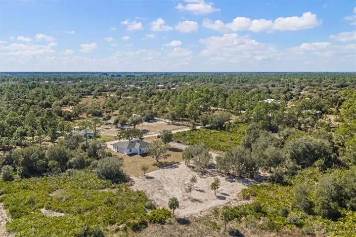 Aerial overview of property's location with a heavily wooded area