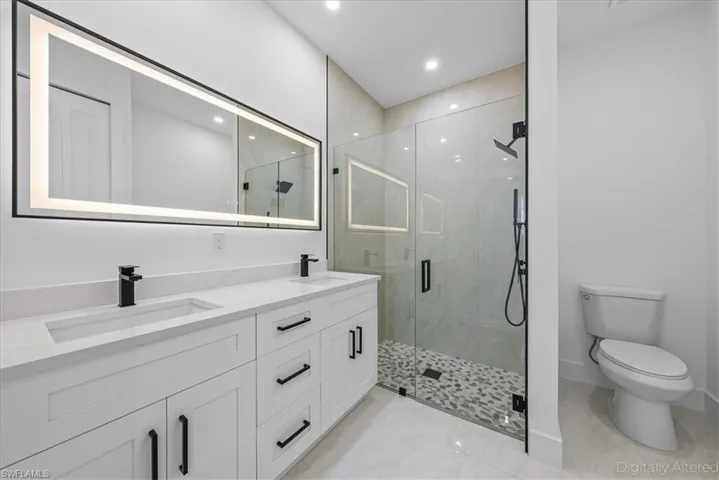 Full bath with double vanity, a stall shower, light tile patterned floors, and recessed lighting