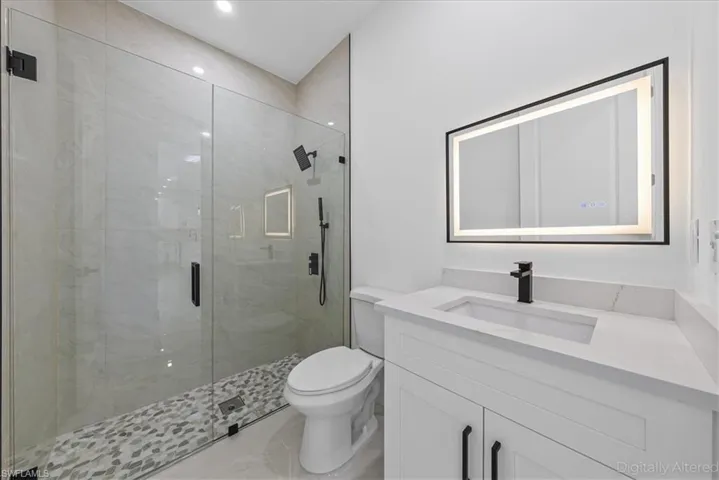 Full bathroom featuring vanity and a shower stall