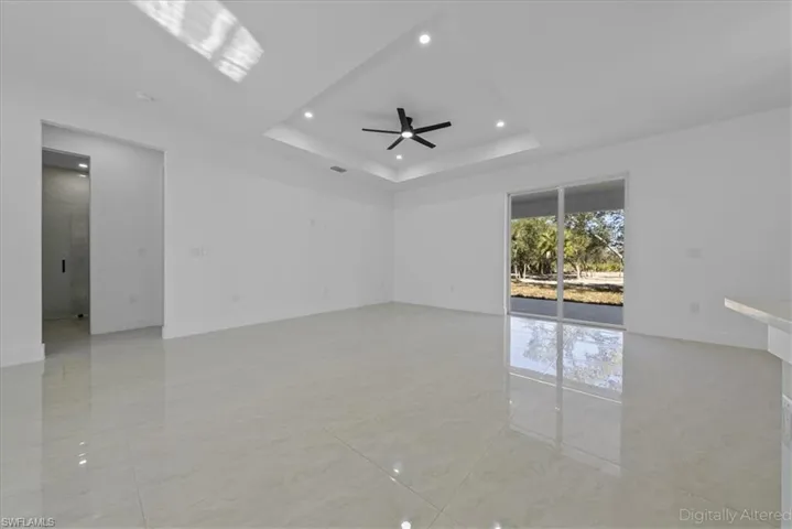 Spare room with a ceiling fan, recessed lighting, and a raised ceiling