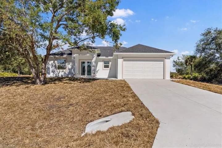 View of front of home featuring french doors, a garage, concrete driveway, and stucco siding