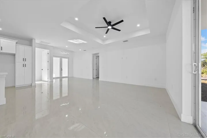 Spare room featuring french doors, recessed lighting, ceiling fan, and a raised ceiling
