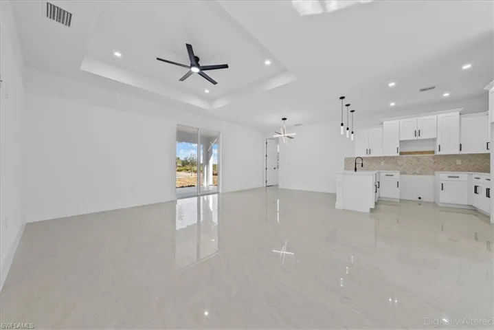 Unfurnished living room with a ceiling fan, recessed lighting, and light tile patterned floors