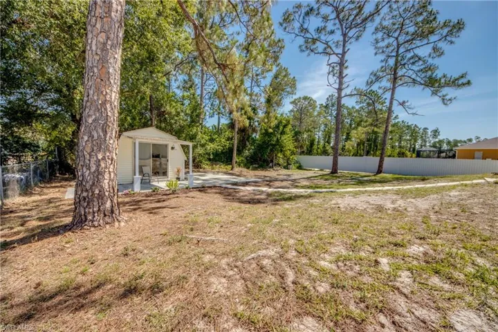 View of yard featuring fence and an outdoor structure