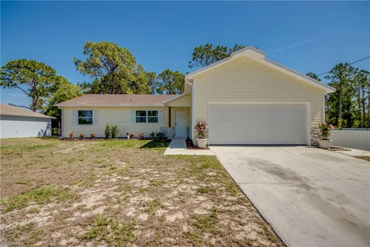 View of front of house featuring an attached garage, concrete driveway, and a front lawn