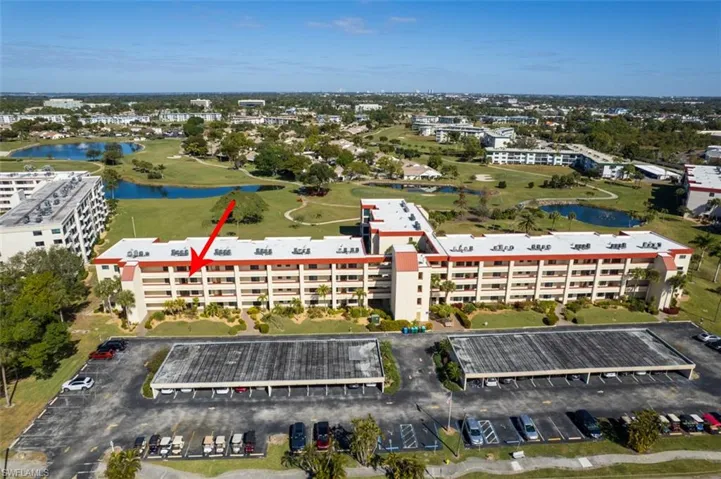 Aerial view of property's location with a golf course and a nearby body of water