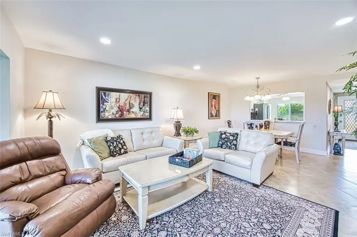 Living area featuring a chandelier and baseboards