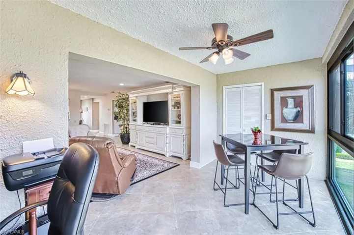 Dining room with a textured wall, a ceiling fan, a textured ceiling, and an office area