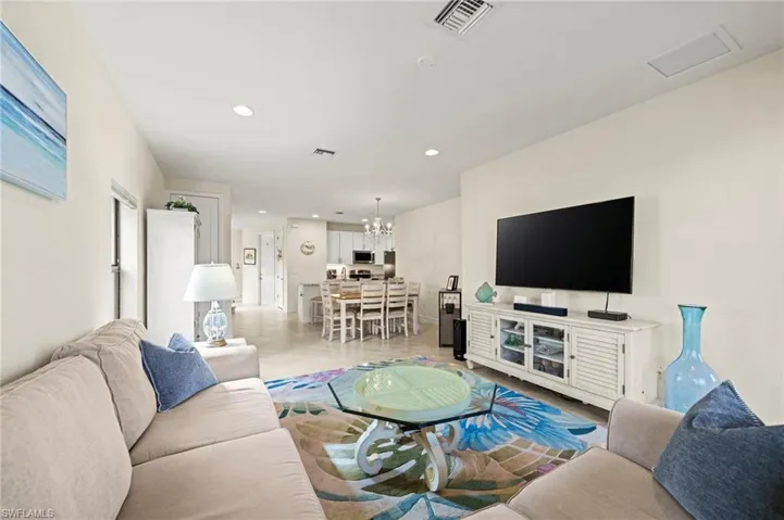 Living area featuring recessed lighting, visible vents, and a notable chandelier
