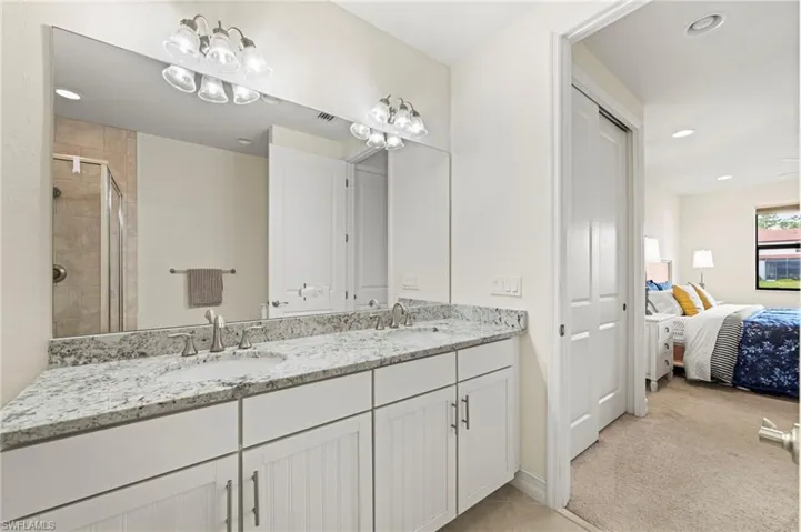 Ensuite bathroom featuring a sink, a shower stall, ensuite bathroom, and double vanity
