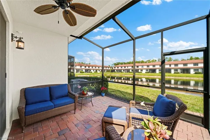 Sunroom / solarium featuring ceiling fan and a water view