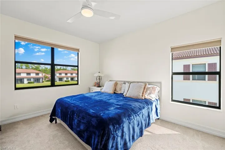 Carpeted bedroom featuring ceiling fan and baseboards