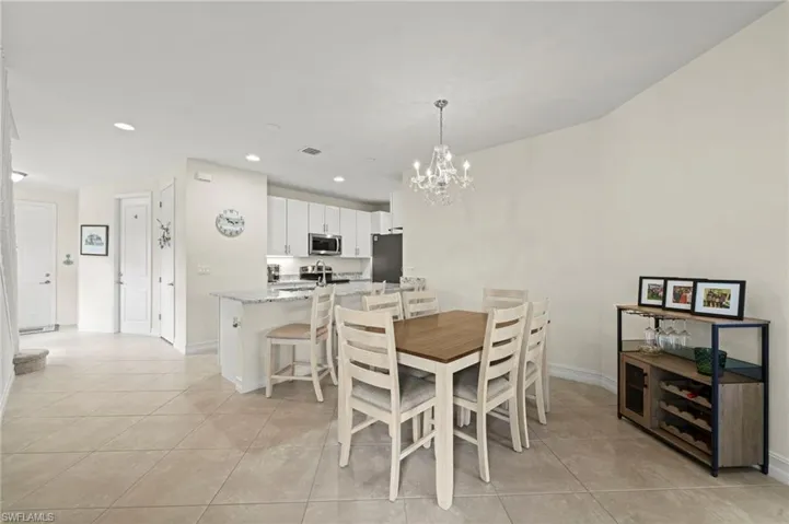 Dining space with recessed lighting, a notable chandelier, baseboards, and light tile patterned floors