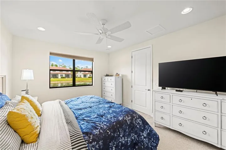 Bedroom with a ceiling fan, recessed lighting, attic access, and light colored carpet