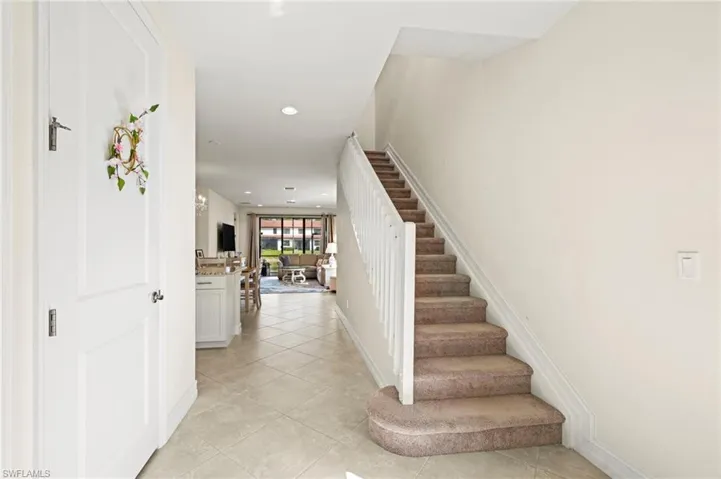 Staircase featuring tile patterned flooring, baseboards, and recessed lighting