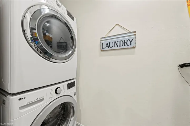 Washroom with stacked washer / dryer and laundry area