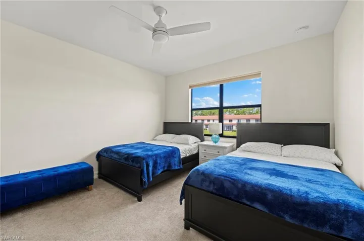Bedroom with ceiling fan and light colored carpet