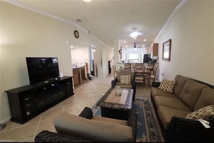 Living area featuring light tile patterned floors, ornamental molding