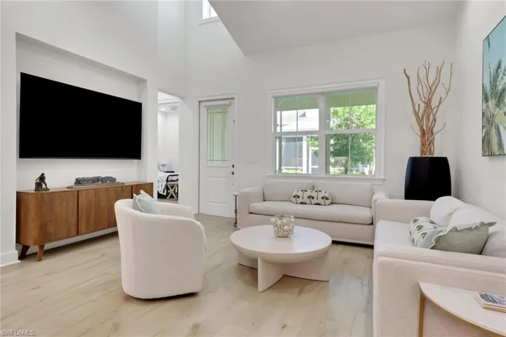 Living room with light wood-style floors and a towering ceiling