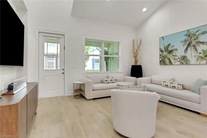 Living room with light wood finished floors and recessed lighting