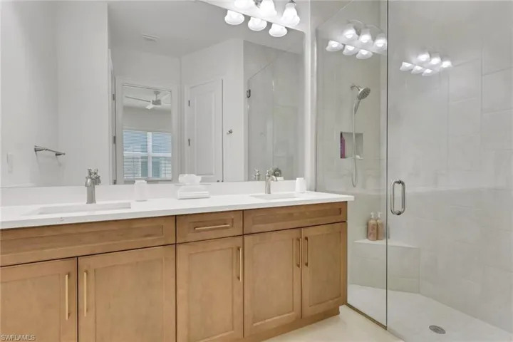 Master bathroom with double vanity and a shower stall