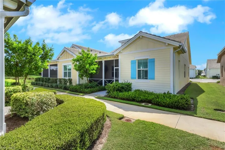 View of front of property featuring a sunroom, board and batten siding, and a front lawn