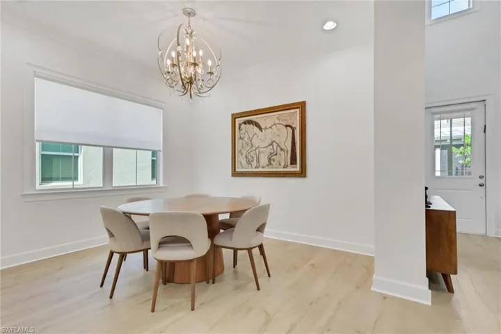 Dining space with light wood-type flooring, a chandelier, ornamental molding, and recessed lighting
