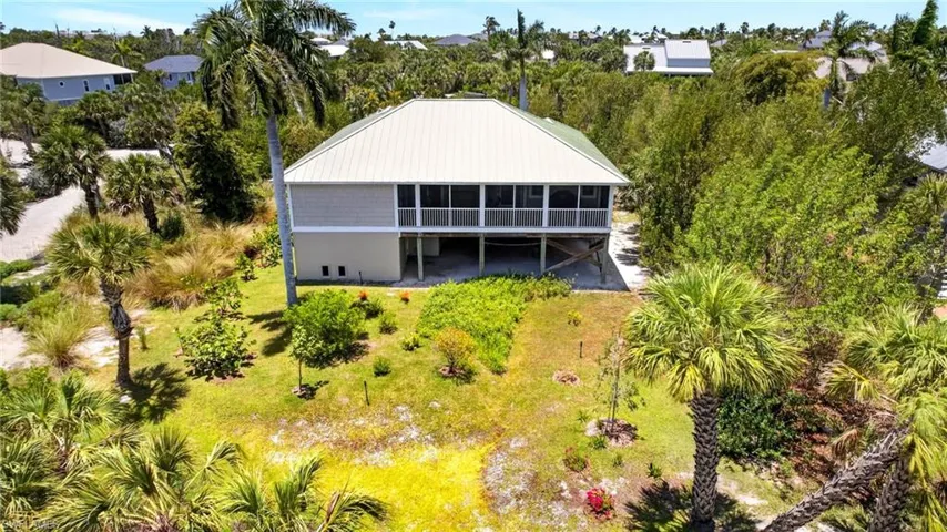 Elevated coastal home featuring a metal roof, screened porch, and ground-level open space
