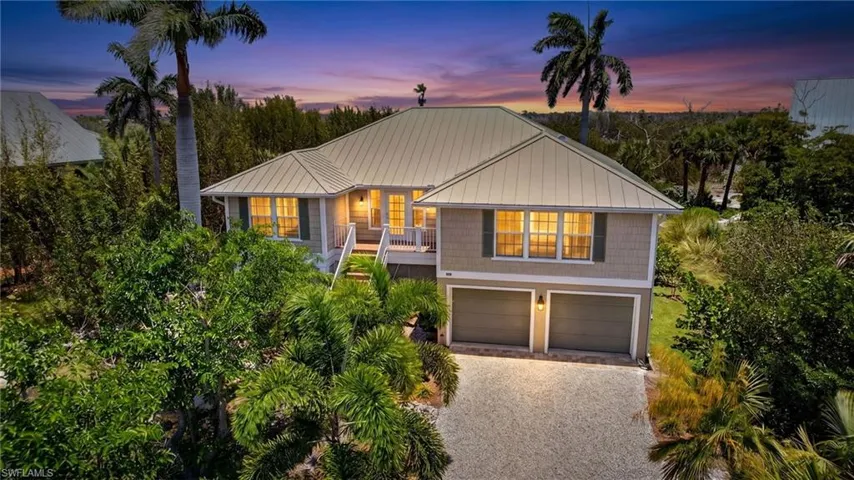 Coastal-style residence with a light-toned metal roof and shake siding