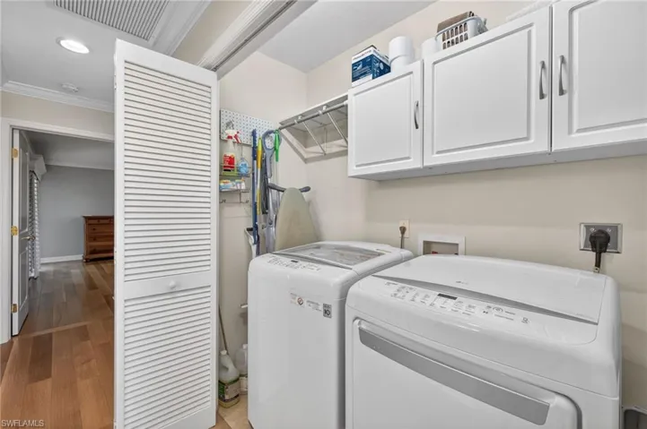Dedicated laundry area featuring white upper cabinetry, a utility shelf, and recessed lighting