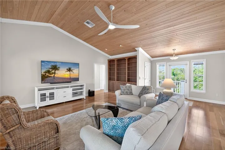 Vaulted ceiling with wood paneling and a modern ceiling fan