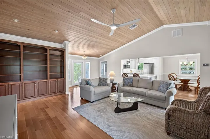 Expansive living area featuring vaulted wood-plank ceilings, recessed lighting, and rich wood-finish flooring