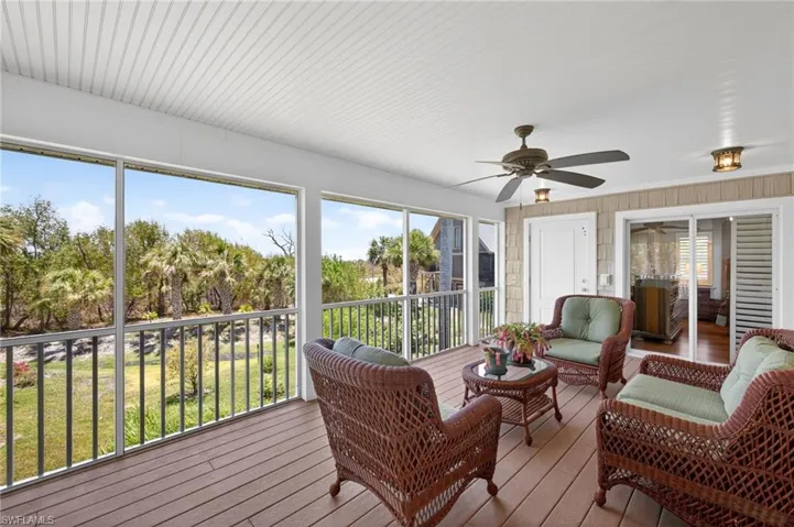 Screened-in porch featuring wood-finish flooring, a white beadboard ceiling, and a ceiling fan