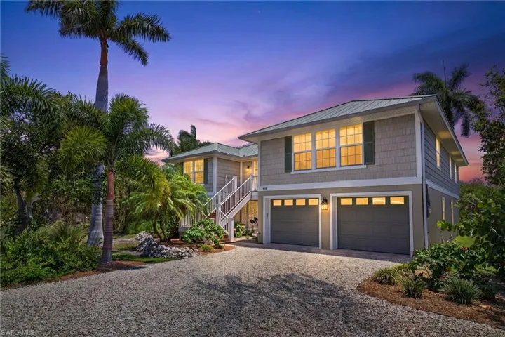 Two-story coastal-style residence featuring a metal roof and shingle siding