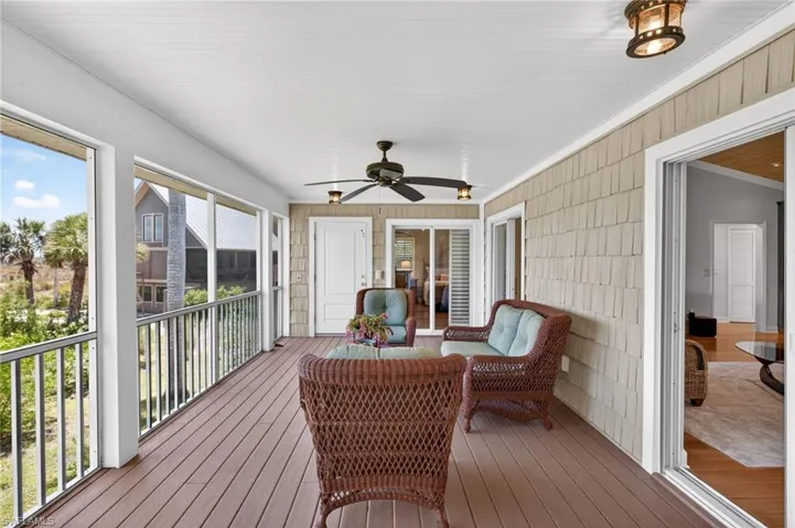 Expansive screened porch featuring wood-finish flooring, a ceiling fan, and decorative light fixtures