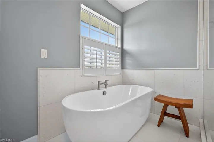 Freestanding soaking tub featuring brushed nickel fixtures