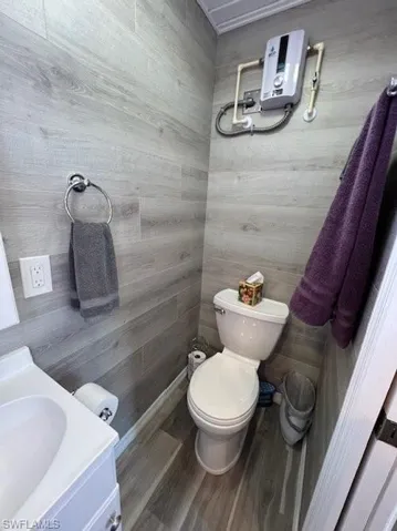 Bathroom featuring toilet, vanity, and wood finished floors