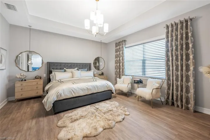 Bedroom with a chandelier, baseboards, and wood finished floors