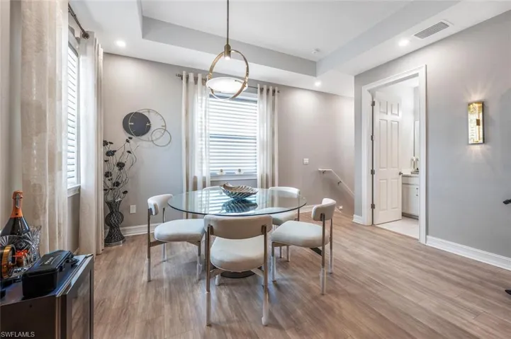 Dining room with light wood-type flooring, recessed lighting, visible vents, and baseboards