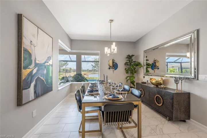 Dining space with a notable chandelier, marble finish floor, and baseboards
