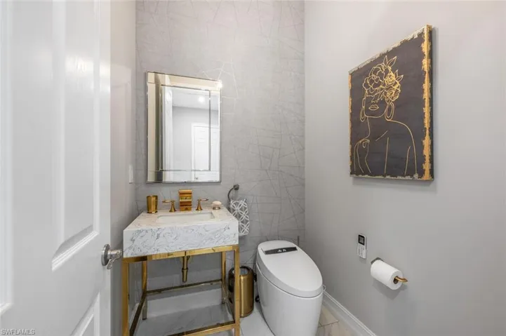 Bathroom featuring toilet, tile walls, and vanity