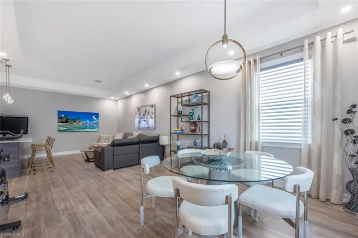 Dining room featuring wood finished floors, a healthy amount of sunlight, and recessed lighting