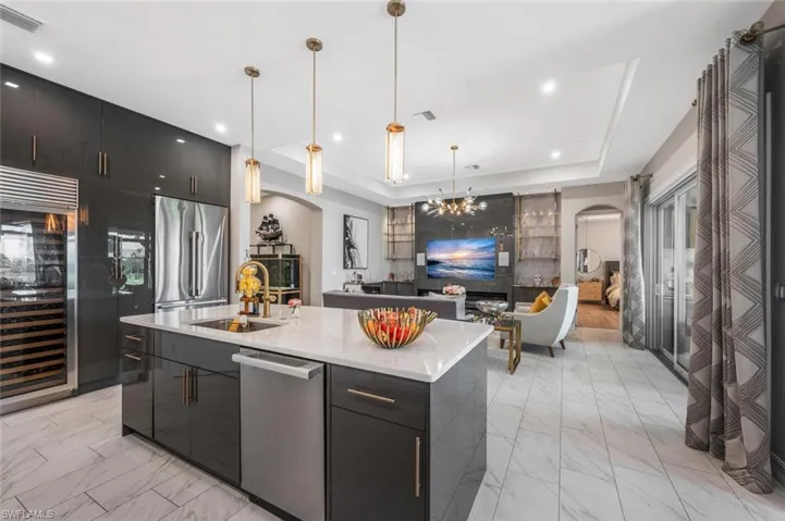 Kitchen featuring a sink, visible vents, stainless steel appliances, arched walkways, and marble finish floor