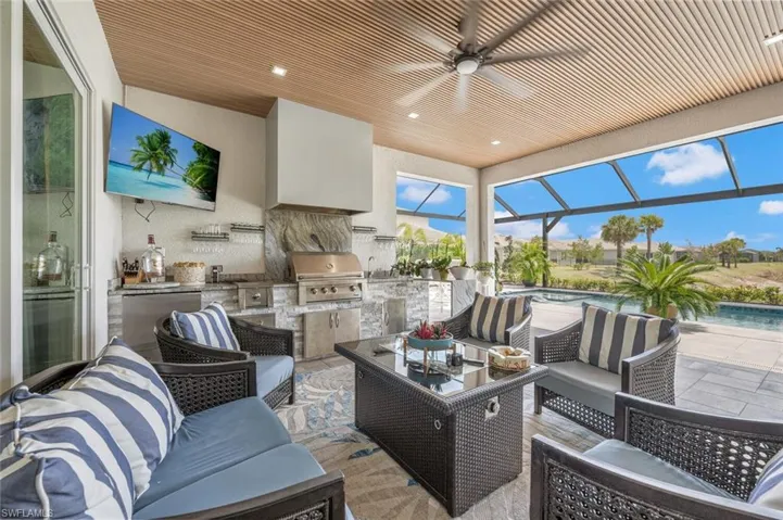 View of patio with an outdoor hangout area, an outdoor pool, area for grilling, ceiling fan, and an outdoor kitchen