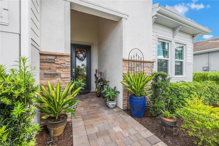 Entrance to property with stucco siding and stone siding