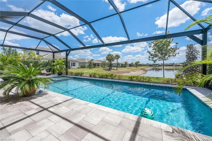 Outdoor pool with a patio, a lanai, and a water view