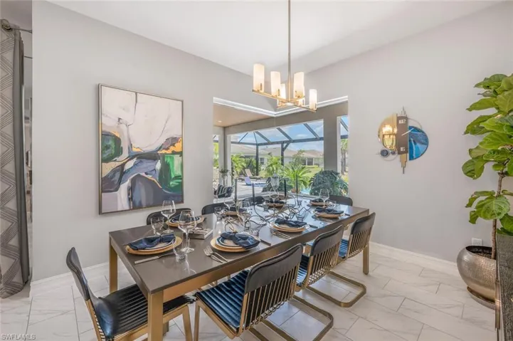 Dining space with baseboards, an inviting chandelier, and marble finish floor